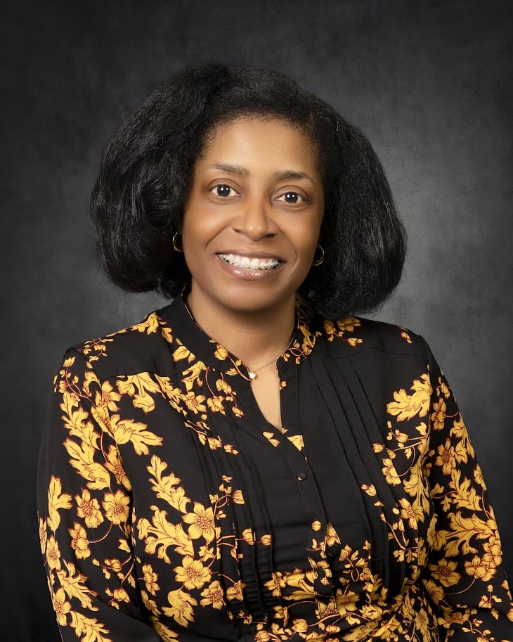 Smiling woman wearing yellow floral blouse