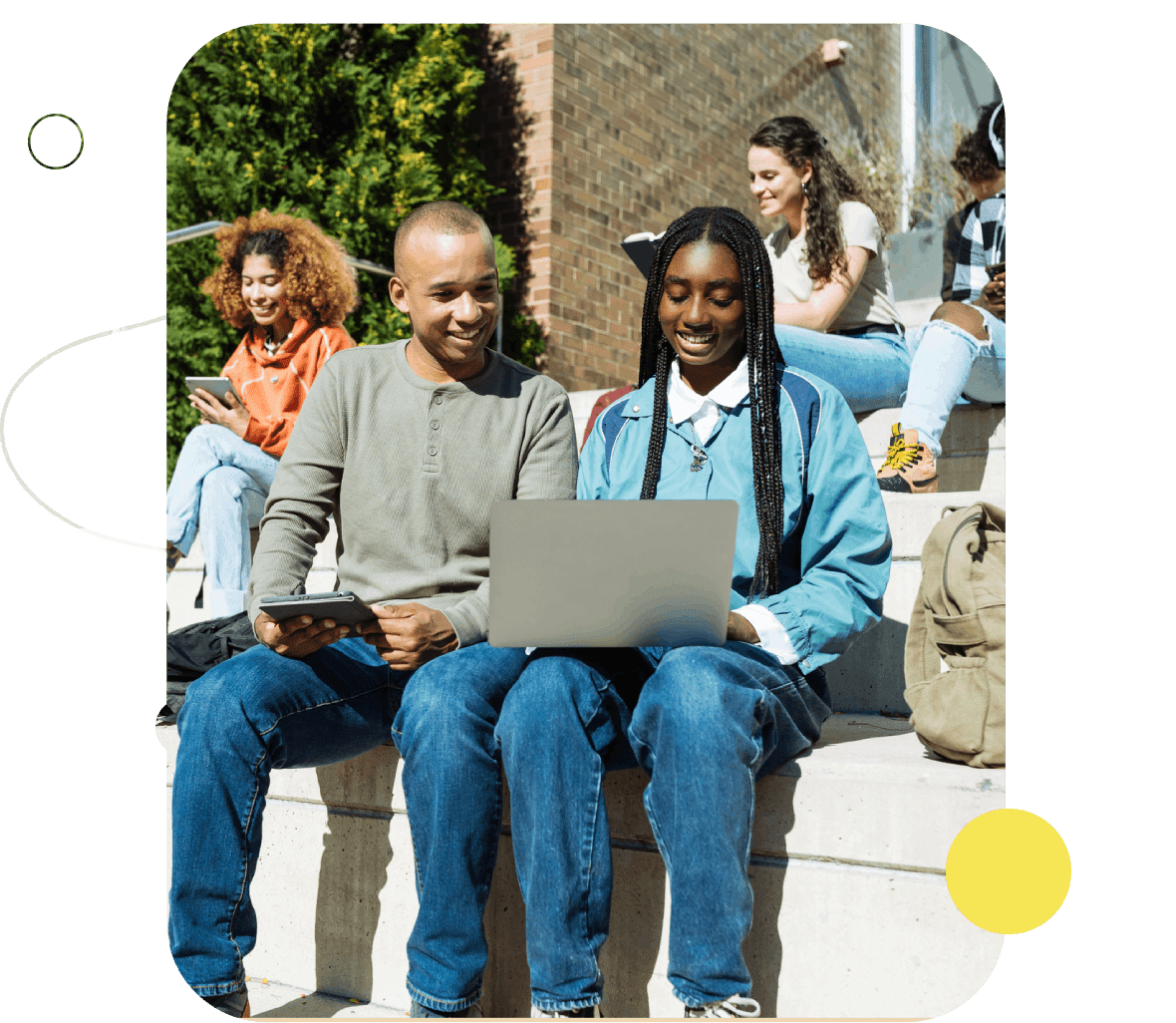 Students sharing laptop on outdoor steps